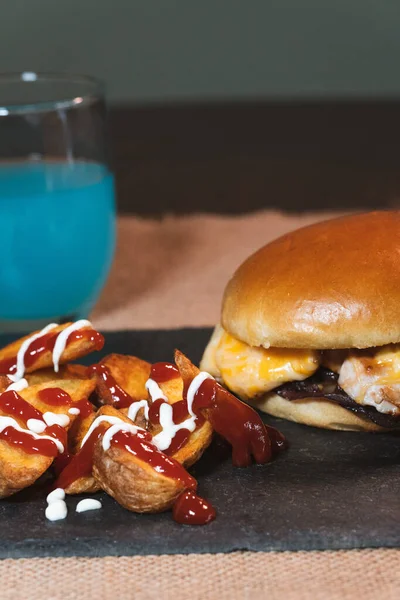 Ketçaplı hindi burger ve mayonez tahtada ve tropikal meyve içeceği. Izgara hindi, karamelli soğan ve iki çeşit peynir..