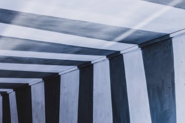 Siyah beyaz çizgilerle boyanmış evde kemer geçişi.