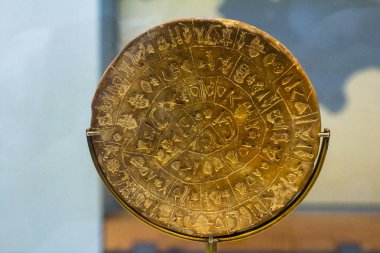 Phaistos Diski. B tarafı. Kırk beş resim işareti taşıyor, altmış bir gruba ayrılmış farklı kombinasyonlar halinde dizilmiş, muhtemelen kelimeleri temsil eden kesik çizgilerle ayrılmış. Heraklion Arkeoloji Müzesi Sergisi
