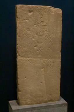 Prinias 'tan mezar taşı. Prinias 'tan oyulmuş bir insan figürüyle birlikte kireçtaşı mezar taşı çeliği. Daha sonraki binalar için yapı malzemesi olarak kullanılıyorlardı ve ünlü ölülerin mezarları için sınır işareti olarak kullanılıyorlardı..