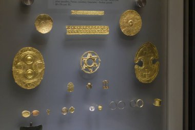 Kalkan, rozet ve kolye şeklinde altın kesikler, sahte dekorasyonlu açık iş süsü, astral sembollü altın Daedalik maske, küpeler, boncuklar ve diğer mücevherler. Prinias, mezarlık, Geometrik dönem, 8-7 sent. BC.