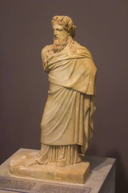 Kafasında çam fıstığı ve sarmaşık çelengi olan Tanrı Dionysus 'un küçük mermer heykeli. Sakalda ve saçta kırmızı renk izleri var. MÖ 300 yılından kalma bir Praxiteles eseri olan Srdanapalus heykeli türünün kopyası..