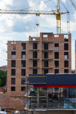 Crane at the construction of a red brick residential building
