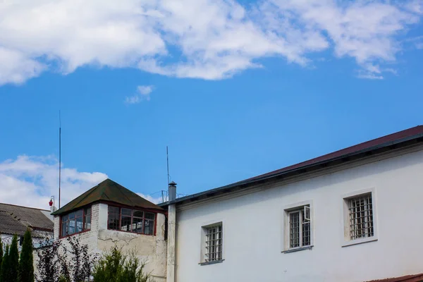 The building of the prison is white and the watchtower with guards