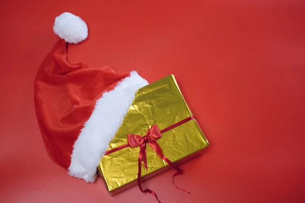 Świąteczne zakupy. Lista zakupów i prezentów na nowy rok. Santa Claus kapelusz leży na złotym polu na czerwonym tle. — Zdjęcie stockowe