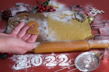 Yılbaşı ve Noel kurabiyeleri yapmak için Hamur. Kurabiye hamurlu tahta bir arka planda kadın elleri.