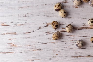 Hafif ahşap arka planda bıldırcın yumurtaları olan bir Paskalya resmi. Paskalya 'nın asgari konsepti. Yazı için yeri olan bir Paskalya kartı..