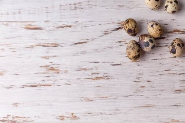 Hafif ahşap arka planda bıldırcın yumurtaları olan bir Paskalya resmi. Paskalya 'nın asgari konsepti. Yazı için yeri olan bir Paskalya kartı..