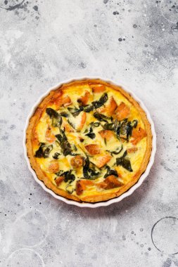 Kırmızı balık ve hafif ahşap zemin üzerine ıspanak ile ev yapımı kiş tart. Vintage tarzı. Üstten Görünüm