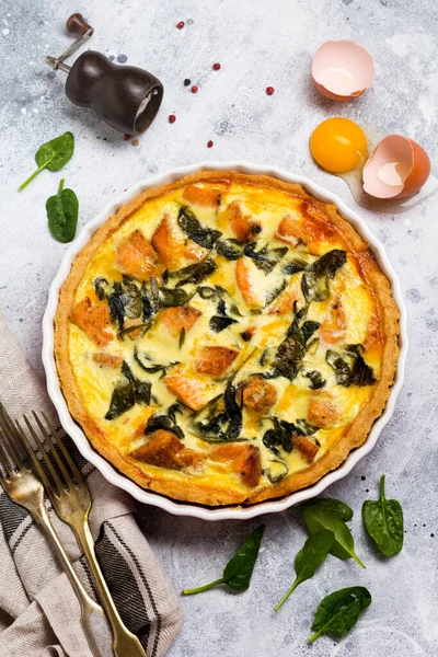 Kırmızı balık ve hafif ahşap zemin üzerine ıspanak ile ev yapımı kiş tart. Vintage tarzı. Üstten Görünüm