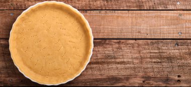 Kiş, tart ya da turta pişirmek için gübre, eski ahşap arka planda mutfak havlusunda pişirilmeye hazır. Üst görünüm, boşluğu kopyala. Tatil için ev yapımı pişirme kavramı. Pankart.