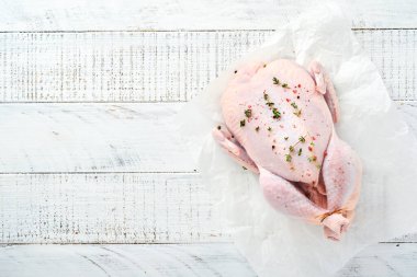 Mutfakta gül biberi, limon, kekik, sarımsak, kirazlı domates ve tuz yapmak için malzemelerle dolu çiğ tavuk açık gri kayrak, taş ya da betondan arka plan manzarası ve fotokopi alanı.