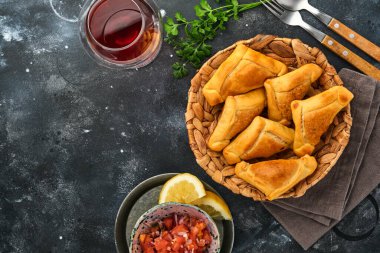 Kişniş, et, yumurta, domates ve siyah arka planda acı biber soslu kızarmış börek. Tipik Şili yemeği. Latin Amerika ve Şili 'nin bağımsızlık günü kavramı.