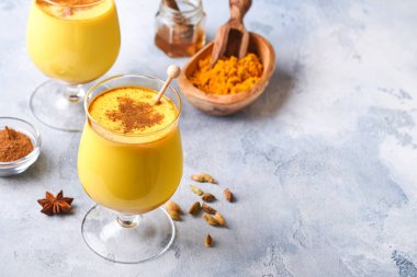 Tarçın çubukları ve ballı zerdeçal altın sütlü latte. Sağlıklı ayurvedic içki. Vejetaryenler için baharatlı Asya doğal detoks içeceği. Boşluğu kopyala.