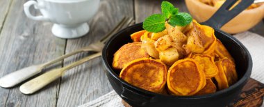 Eski ahşap arka planda çikolata soslu küçük balkabağı gözlemeleri. Seçici odak.