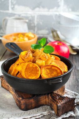 Eski ahşap arka planda çikolata soslu küçük balkabağı gözlemeleri. Seçici odak.