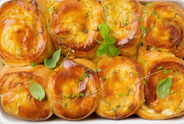 Açık ahşap arka planda peynirli çörekler ve mayalı fesleğen. Seçici odaklanma. Kırsal stil. Üst görünüm.