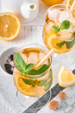 Geleneksel buzlu çay, limon ve buzlu uzun bardaklarda mermer masa üzerinde buzlu limonlu çay. Seçici odaklanma. Soğuk yaz içeceği..