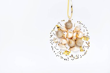 Noel kompozisyonu. Toplardan yapılmış altın bir Noel topu ve beyaz arka planda konfeti. Düz yerde, üst tarafta. Sihirli Noel tebrik kartı. Sınır tasarımı. Model.