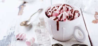 Sıcak çikolata hatmi şekerler eski ışık vintage ahşap arka plan üzerinde beyaz Rustik seramik Kupası ile. Seçici odak.