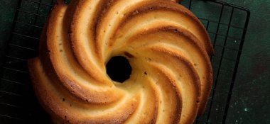 Şeker sır ve koyu yeşil eski beton zemin üzerine Hindistan cevizi ile kek. Seçici odak. Kopya alanı ile üstten görünüm.