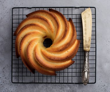 Şeker sır ve koyu gri eski beton zemin üzerine Hindistan cevizi ile kek. Seçici odak. Kopya alanı ile üstten görünüm.