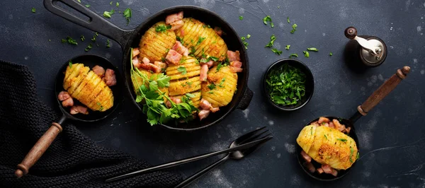 Baked potatoes with ham, herbs and breadcrumbs on dark background. Scandinavian cuisine. Top view.