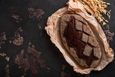 Taze ev yapımı çavdar ekmeği. Kırsal ahşap arka planda dilimlere ayrılmış geleneksel hecelenen ekşi mayalı ekmek. Geleneksel mayalanmış ekmek pişirme yöntemleri kavramı. Seçici odak.