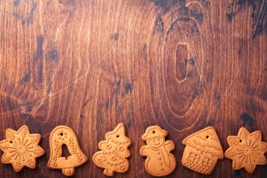 Noel ağacı dalları, Noel baloları, Noel zencefilli çörekleri, hediye kutusu, tahta kar taneleri ve eski ahşap arka planda eski Noel kutlamaları için yıldızlar. Üst görünüm, boşluğu kopyala. Noel tebrik kartı..