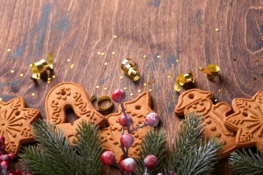 Noel ağacı dalları, Noel baloları, Noel zencefilli çörekleri, hediye kutusu, tahta kar taneleri ve eski ahşap arka planda eski Noel kutlamaları için yıldızlar. Üst görünüm, boşluğu kopyala. Noel tebrik kartı..