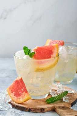 Limonata, greyfurt, soda ve nane yapraklarından yapılmış açık mavi kayrak, taş ya da beton zemin üzerinde buz. Sağlıklı ev yapımı limonata veya kokteyl. Model yap. Üst görünüm.