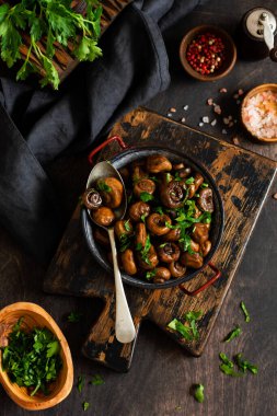 Soya sosunda kızartılmış mantar şampiyonu, biberli ve eski bir masada eski bir metal kasede buğulanmış soğan. Seçici odak