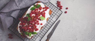 Sır ve gri beton antika arka plan üzerinde kırmızı kuş üzümü ile kek. Tonlu görüntü. Üstten görünüm