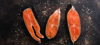 Oda arkadaşı somon ile baharat, ot, tuz ve limon eski taş zemin üzerine çiğ biftek. Üstten görünüm kopya alanı