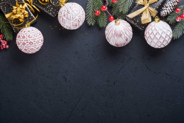 Tatil hediyesi kutusu ya da kurdele, altın konfeti ve siyah arka planda altın takılar. Sihirli Noel tebrik kartı. Noel süslemesi. Sınır tasarımı. Model yap. Üst görünüm.