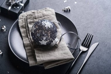 Noel ağacı dallarıyla siyah renkli Noel masası, Noel gümüş topları ve şampanya, yılbaşı kutlamaları için siyah arka planda gözlük. Mutlu Noeller ve mutlu yıllar konsepti