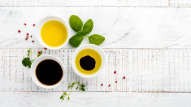 Soya sosu, zeytin yağı ve balsamik soslu otlar fesleğen, maydanoz, biber ve kekik Beyaz ahşap zemin üzerinde. Üstten görünüm.