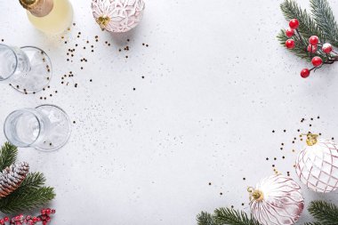 Noel masasında siyah çatal bıçak takımları, Noel ağacı olarak katlanmış peçeteler, Noel gümüş topları, şampanya, beyaz arka planda yeni yıl kutlamaları için bardaklar. Metin için boş boşluk.
