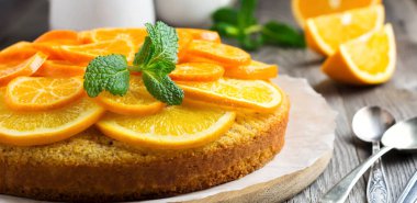 Turuncu ve mandalinalı kek, eski ahşap arka planda baş aşağı duruyor. Seçici odak.