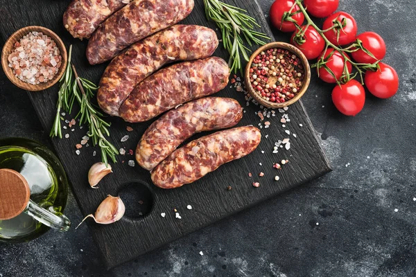 Çiğ sosis ya da sucuk ve koyu taş arka planda pişirmek için malzemeler. Kopyalama alanı olan üst görünüm.