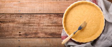 Kiş, tart ya da turta pişirmek için gübre, eski ahşap arka planda mutfak havlusunda pişirilmeye hazır. Üst görünüm, boşluğu kopyala. Tatil için ev yapımı pişirme kavramı.