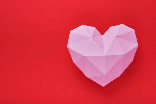 ピンクの紙の心は赤い背景に隔離されています バレンタインデーやその他の愛の招待状のための赤い多角形の紙の心 トップビュー コピースペース — ストック写真
