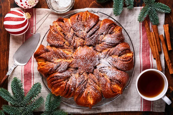 Noel yıldızı çikolata ve tarçınlı ekmeği eski ahşap masaya ördü. Uzayı metin için kopyala. Üst görünüm