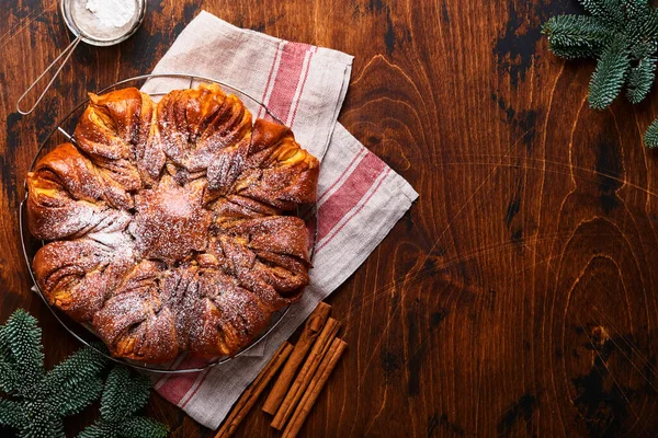 Noel yıldızı çikolata ve tarçınlı ekmeği eski ahşap masaya ördü. Uzayı metin için kopyala. Üst görünüm