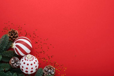 Beyaz ve kırmızı takı balosu, hediye kutusu ve kırmızı arka planda süslenmiş kurdele ve köknar ağacı dallarıyla Noel veya yeni yıl konsepti. Mutlu yıllar 2022. Model.