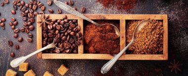 Üç çeşit kahve ile gıda arka plan: fasulye, öğütülmüş, anlık eski beton kahverengi zemin ahşap kutusunda. Rustik stile. Seçici odak. Üstten görünüm.