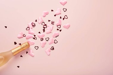 Sevgililer günü tebrik kartı, şampanya şişesi, çekici gözlükleri, çikolata kalpleri ve pembe arka planda hediye kutusu. Selamlaşmak için en iyi manzara. Kopyalama alanı olan tebrik kartı.