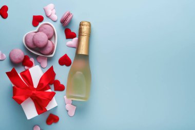 Sevgililer Günü kartı. Kırmızı kurdeleli beyaz hediye kutuları, şampanya şişesi ve mavi arka planda kurabiye. 8 Mart, Kadınlar Anneler Günü, Doğum Günü. Model.