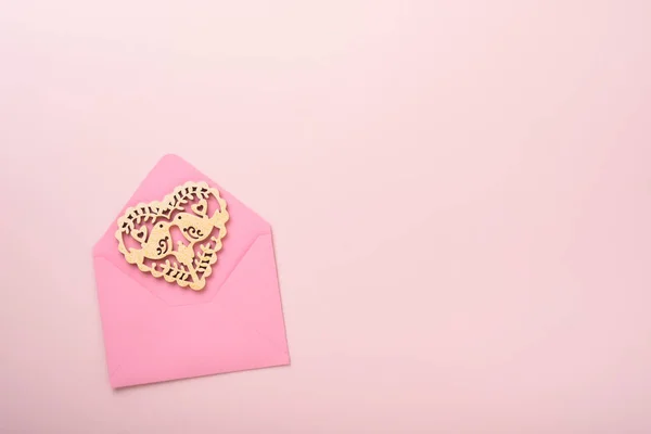 ピンクの背景にホワイトの透かし彫りハートとレッドのリボンがあしらわれたピンクの封筒 コピースペース付きのトップビュー バレンタインデーや結婚式のロマンチックなコンセプト 祝祭の構成 モックアップ — ストック写真