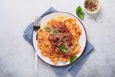 Domates soslu Tagliatelle makarnası ve açık gri kayrak, taş ya da beton arka planda kekik soslu. Geleneksel İtalyan yemeği ve mutfağı. Kopyalama alanı olan üst görünüm.